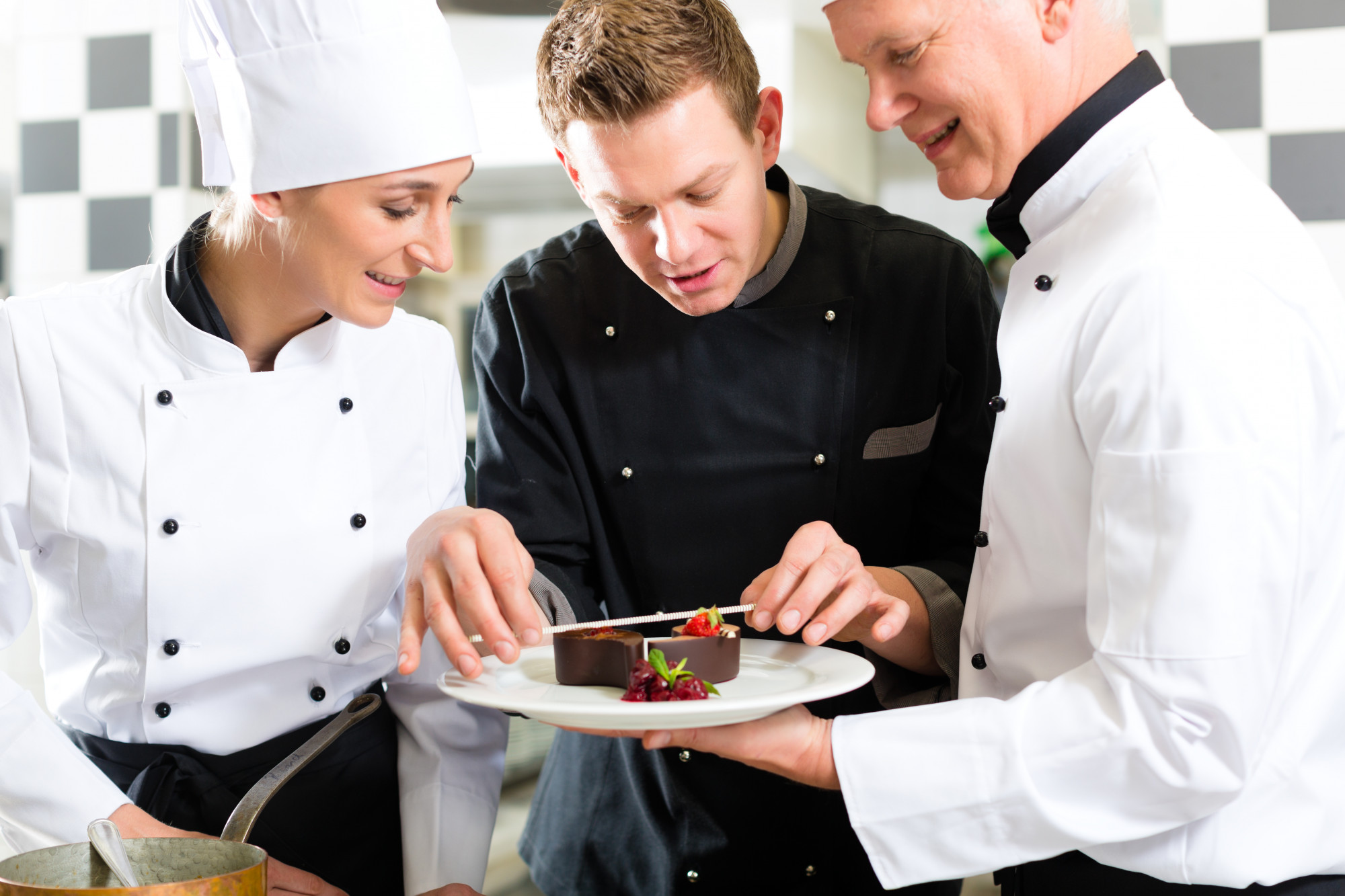 chef demonstrating plating to small team